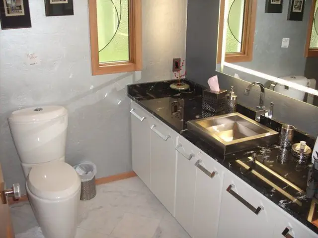 Full bathroom with a toilet, black granite vanity and stainless vessel sink