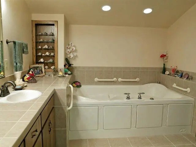 Completed corner jetted tub fitted with grab bars