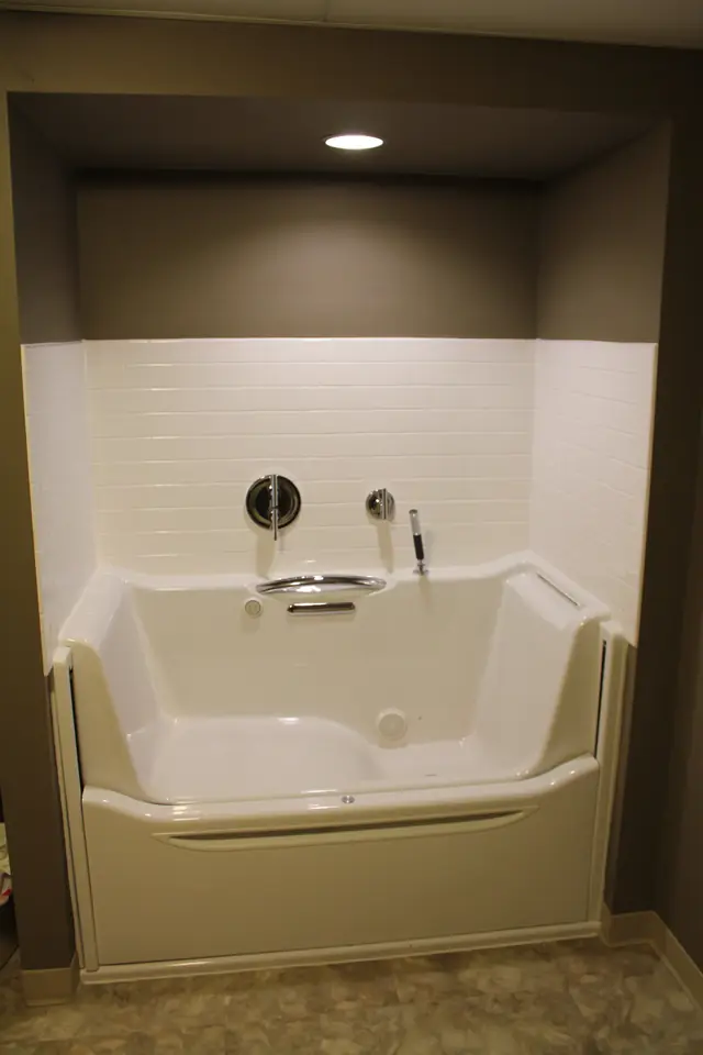 Accessible walk in soaking tub with a barrier free access door and subway tile