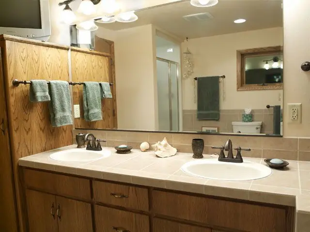 Dual sink vanity with a tile counter and oil rubbed bronze fixtures