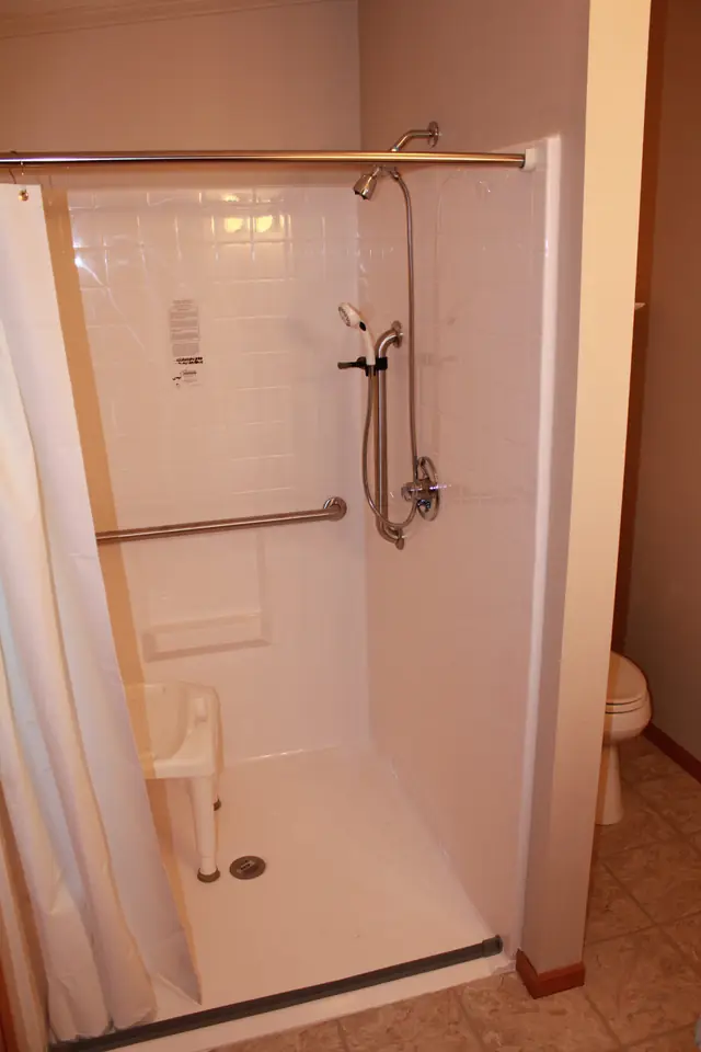 Accessible roll in shower with grab bars and a fold down shower seat