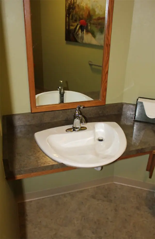 Wall mounted sink with wheelchair clearance in a commercial washroom